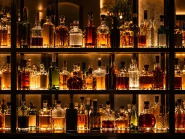 des bouteilles de spiritueux disposées sur des étagères lumineuses